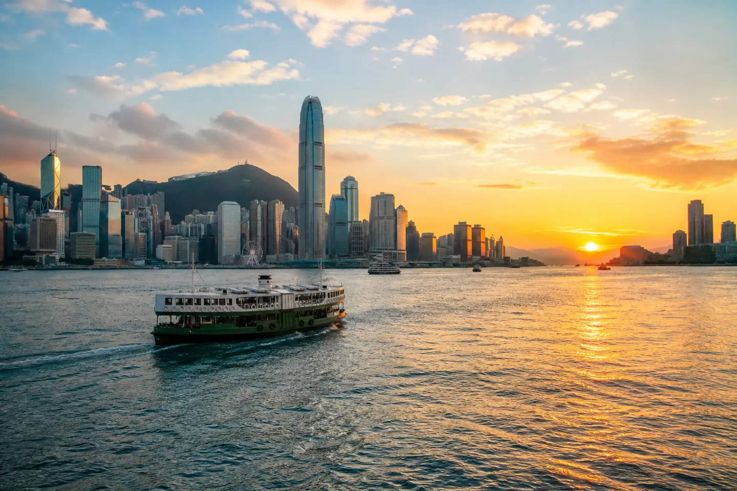 Hong Kong skyline across Victoria Harbour at golden hour