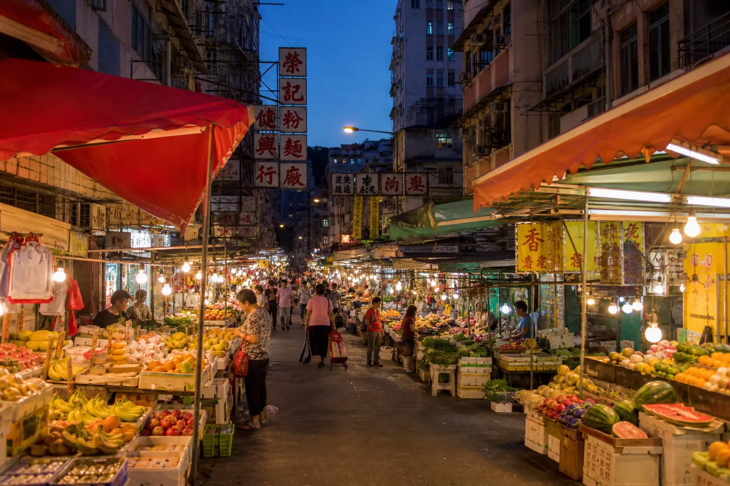 A street market at dusk. Ten words of Cantonese changes this from a photo opportunity into your Tuesday shop.